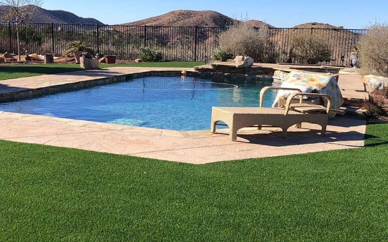 Artificial turf around a backyard pool installed by HaloTurf